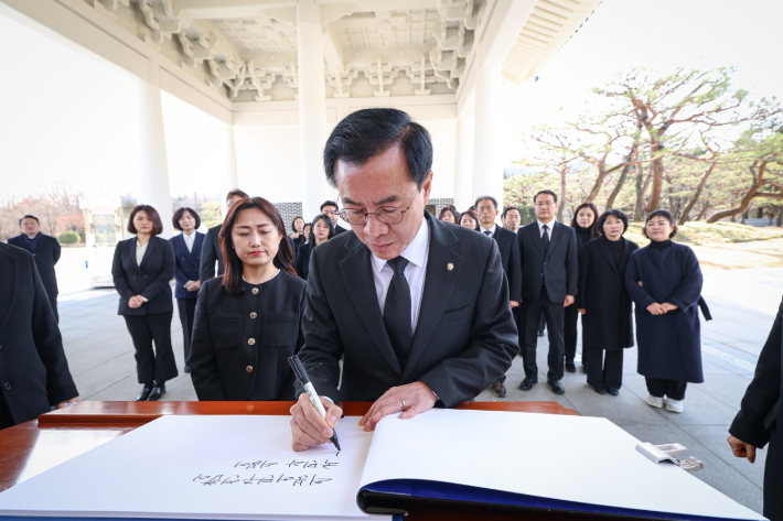 더불어민주당의 비례대표 위성정당인 더불어민주연합 윤영덕 공동대표가 18일 비례대표 후보자들과 함께 동작구 국립서울현충원을 참배한 뒤 방명록을 쓰고 있다. 연합뉴스