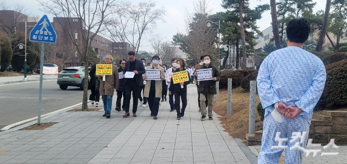 이주호 교육부 장관이 충북대를 방문한 19일 의대 교수들과 의대생들이 대학 본부 앞에서 피켓 시위를 벌이기 위해 행진하고 있다. 최범규 기자
