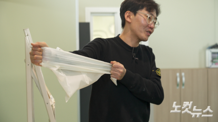 라이스팜 박재민 대표가 쌀로 만든 플라스틱 대체재료로 찍어낸 비닐 봉지를 당겨보고 있다. 일반 플라스틱 비닐보다 인장력이 강하다. 권혁주 기자