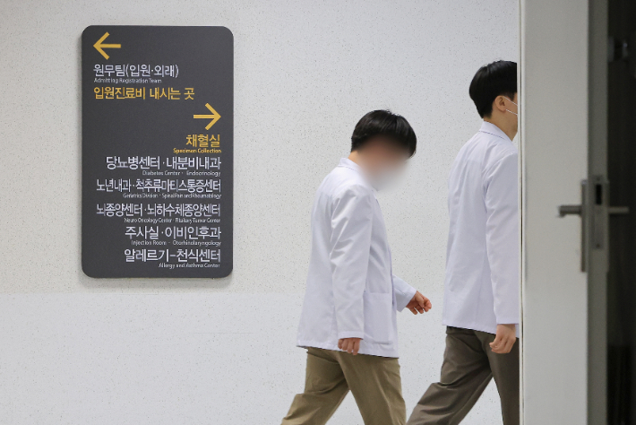 전국 의과대학 교수들의 집단 사직이 가시화하는 가운데 19일 서울 시내 한 대학병원에서 의료진이 이동하고 있다. 연합뉴스