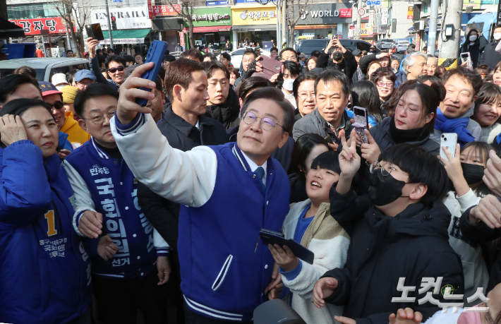 더불어민주당 이재명 대표가 20일 인천시 미추홀구 신기시장을 찾아 시민과 인사하며 셀카를 찍고 있다. 윤창원 기자