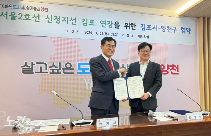 21일 서울2호선 신정지선의 김포 연장을 위한 협약식에서 김병수(오른쪽) 김포시장과 이기재 서울 양천구청장이 손을 맞잡았다. 박창주 기자