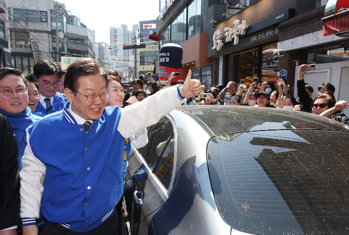 더불어민주당 이재명 상임공동선대위원장이 21일 광주 전남대 후문 상가 밀집지역을 방문, 이 지역에 출마한 후보들과 함께 거리 인사를 하고 있다. 연합뉴스
