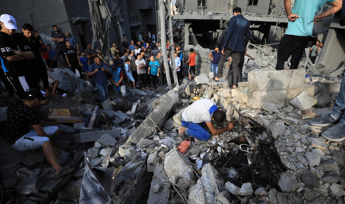 가자지구 알마가지 난민촌에서 주민들이 이스라엘 공습으로 무너진 건물 잔해를 살펴보고 있다. 연합뉴스