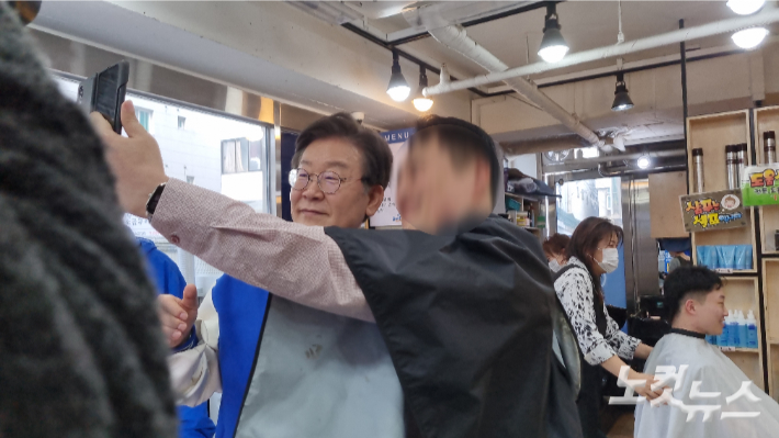 더불어민주당 이재명 대표가 26일 서울 동작 노량진의 한 미용실을 찾고 시민과 사진을 찍고 있다. 백담 기자