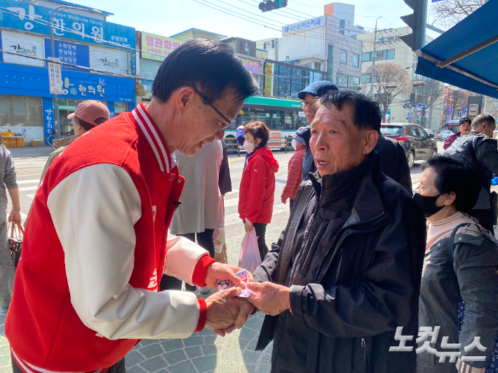 지난 2일 지동못골시장 입구에서 국민의힘 방문규 후보가 시민에게 명함을 건네고 있다. 김도균 인턴기자