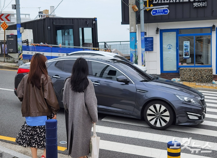 부산 영도구 흰여울길 앞 신호등이 꺼진 횡단보도에서 관광객이 길을 건너려 하지만 차량이 계속 지나가고 있다. 정혜린 기자