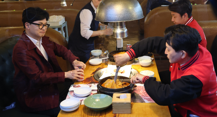 국민의힘 한동훈 비상대책위원장이 8일 저녁 인천 계양구 한 고깃집에서 원희룡 후보와 만나고 있다. 원 후보 옆은 이천수 전 축구 국가대표. 연합뉴스