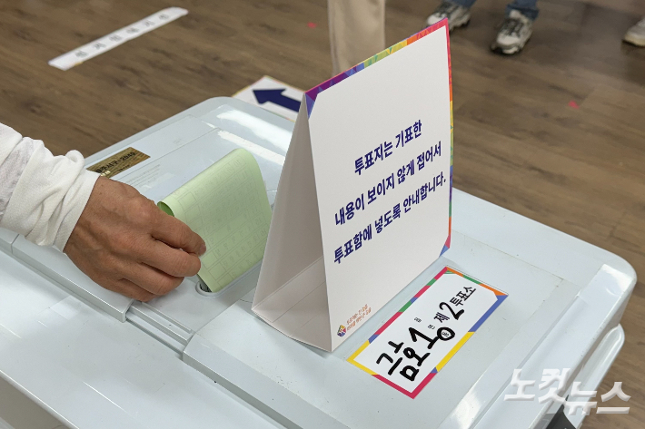 22대 총선 본투표소가 마련된 광주 서구 금호중학교에 10일 오전 6시 30분 유권자가 투표함에 투표용지를 넣고있다. 김수진 기자