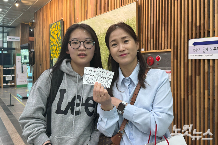22대 총선 본투표소가 마련된 광주 서구 서구문화센터에 10일 오전 10시쯤 18세 유권자가 어머니와 함께 투표 인증 사진을 촬영하고 있다. 김수진 기자