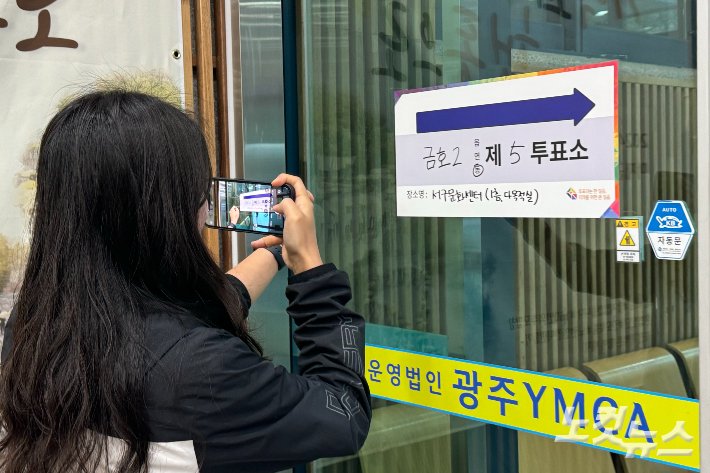 22대 총선 본투표소가 마련된 광주 서구 서구문화센터에 10일 오전 7시쯤 유권자가 투표 인증 사진을 촬영하고 있다. 김수진 기자