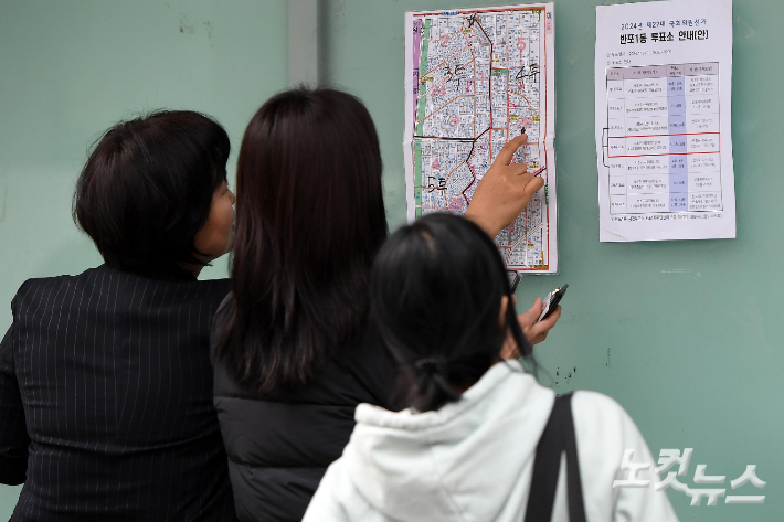 유권자들이 지정 투표소 안내를 받고 있다. 박종민 기자