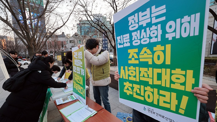 지난달 13일 오후 서울 종로구 동화면세점 앞에서 보건의료노조가 의사들의 진료거부 중단을 촉구하는 범국민 서명운동을 하는 모습. 연합뉴스