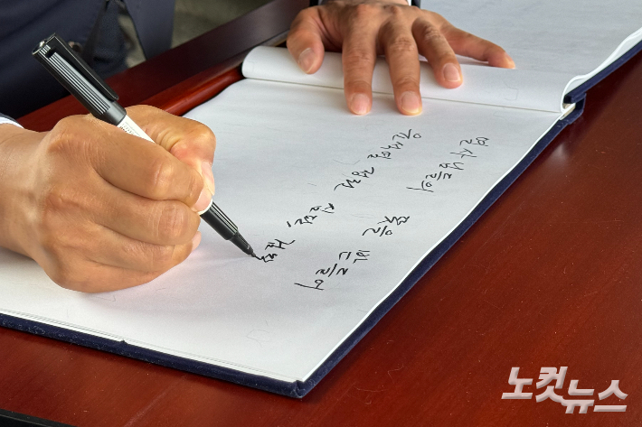 제22대 국회의원 선거 광주 광산갑 박균택 당선인이 11일 오전 광주 북구 운정동 국립 5·18 민주묘지에서 방명록을 작성하고 있다. 김수진 기자