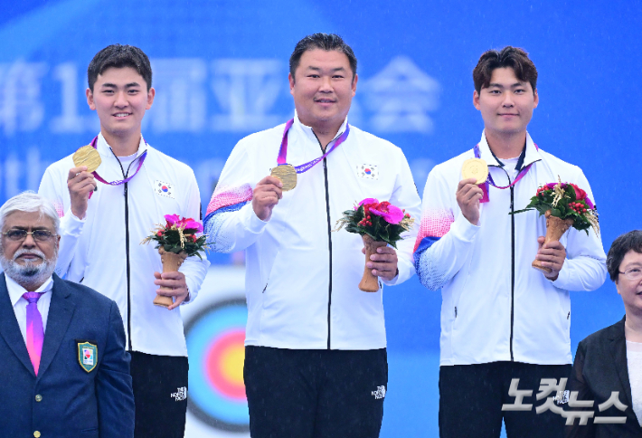 중국 항저우 푸양 인후 스포츠센터에서 열린 2022 항저우 아시안게임 양궁 리커브 남자 단체 결승전 인도와의 경기에서 금메달을 획득한 김제덕(왼쪽부터), 오진혁, 이우석이 시상대에서 기념촬영 하고 있다. 황진환 기자