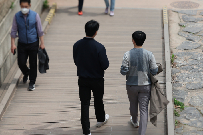 점심시간 서울 청계천에서 시민들이 겉옷을 들고 산책을 하고 있다. 연합뉴스