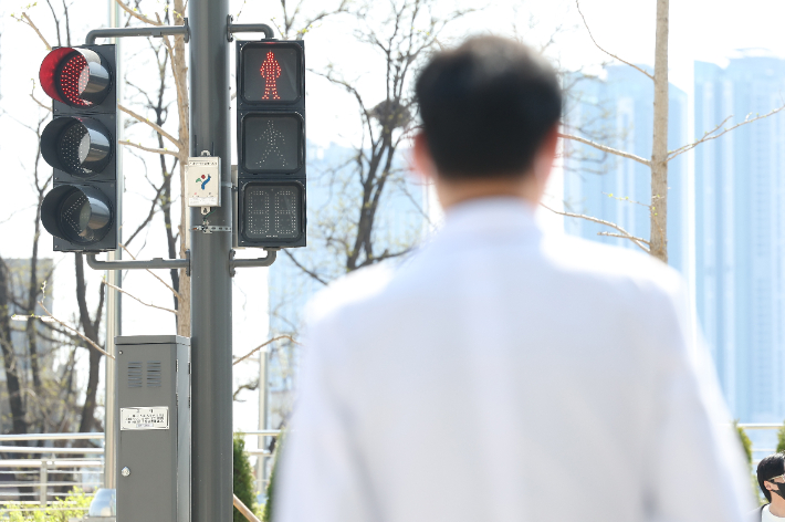'전공의 집단행동이 이어지고 있는 지난 9일 오전 서울 시내 한 대형병원에서 한 의료 관계자가 횡단보도 신호를 기다리고 있다. 연합뉴스