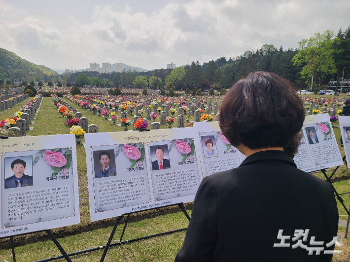 대전현충원 순직공무원묘역에서 열린 기억식에서 순직 교사들을 소개하는 사진과 글을 유가족이 바라보고 있다. 김정남 기자