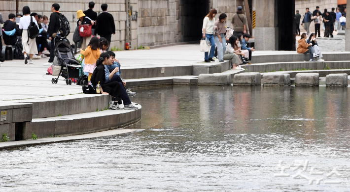 따뜻한 봄 날씨를 보이고 있는 23일 오후 서울 종로구 청계천을 찾은 시민들이 휴식을 취하고 있다. 황진환 기자