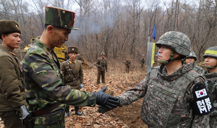 지난 2018년 도로연결 작업에 참여한 남북인원들이 군사분계선(MDL) 인근에서 인사하는 모습. 연합뉴스