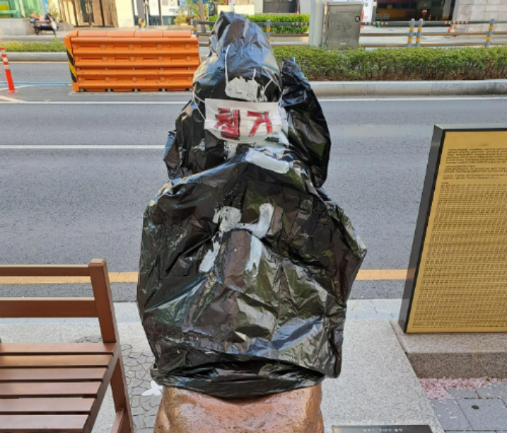 부산소녀상이 '철거'라는 글씨가 붙은 검은 봉지에 싸여있다. 연합뉴스