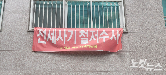 신탁사기 등에 대한 수사를 촉구하는 현수막이 아파트 외벽에 붙어 있다. 박창주 기자