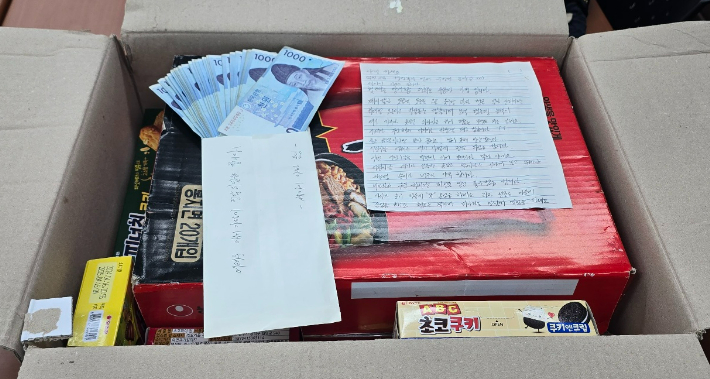지난 6일 오전 부산 북부경찰서 덕천지구대에 놓여진 상자에 어려운 아이 가정에 전달해달라는 편지와 함께 현금, 물품이 가득 차 있다. 부산경찰청 제공