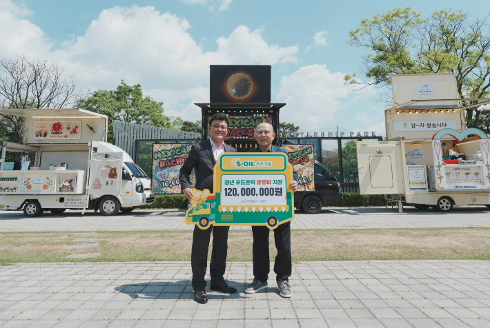 에쓰오일 안종범 마케팅총괄 사장(왼쪽)과 함께일하는재단 이세중 이사장이 8일 서울 마포구 망원한강공원에서 열린 '청년 푸드트럭 유류비 전달식'에서 기념 촬영을 하고 있다. 에쓰오일 제공