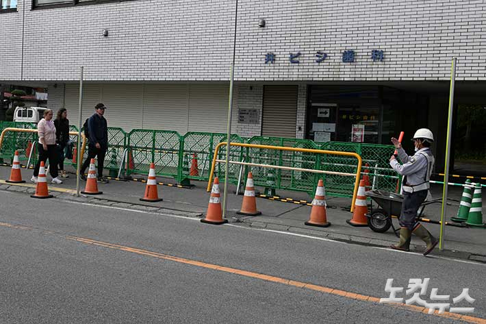 후지 가와구치코 로손 에키마에점 도로 건너편 인증샷 촬영 포인트에서 사진 촬영을 하려는 관광객이 제지 당하는 모습. 최원철 기자