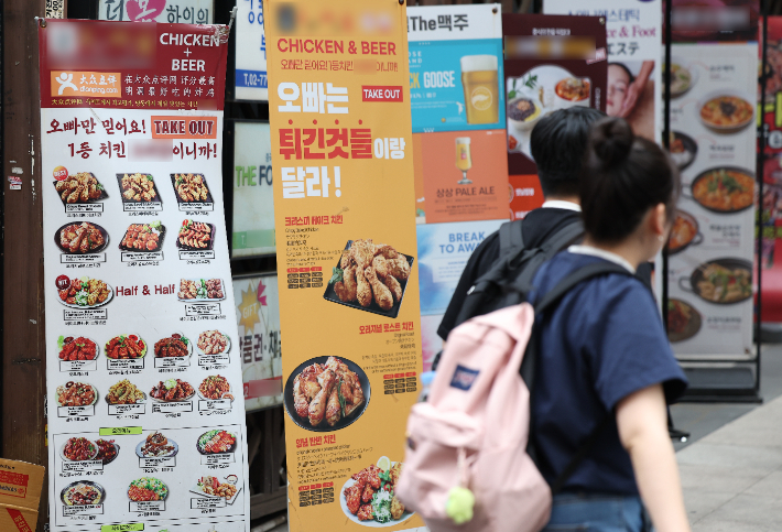 김밥과 치킨, 피자 등 외식 품목 가격 인상이 이어지고 있는 가운데 서울 중구 명동 거리 한 음식점에 치킨 메뉴 사진 안내판이 붙어 있다. 연합뉴스