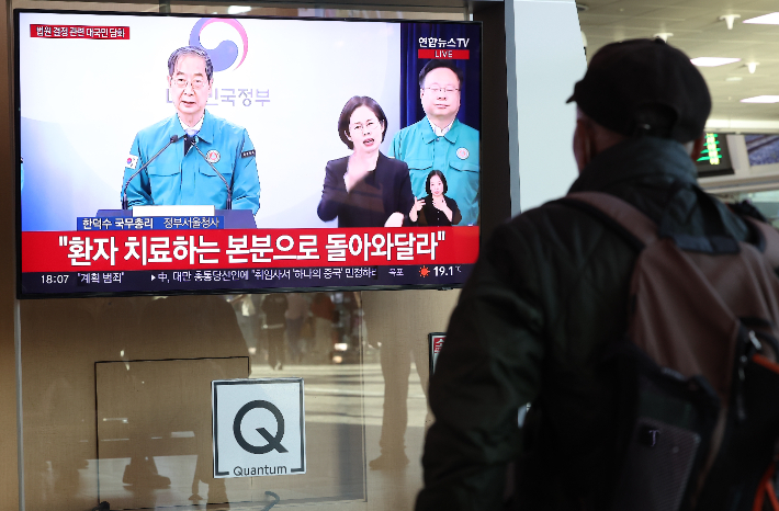 16일 오후 서울 중구 서울역에서 시민들이 한덕수 국무총리의 '의대 정원 관련 대국민담화' 발표 방송을 지켜보고 있다. 연합뉴스