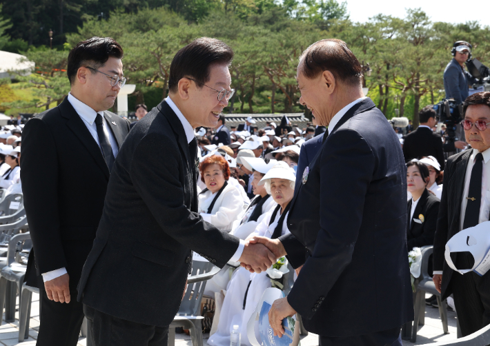 국민의힘 황우여 비상대책위원장(오른쪽)과 더불어민주당 이재명 대표가 18일 광주시 북구 국립5·18민주묘지에서 열린 제44주년 5·18민주화운동 기념식에서 만나 악수하고 있다. 연합뉴스