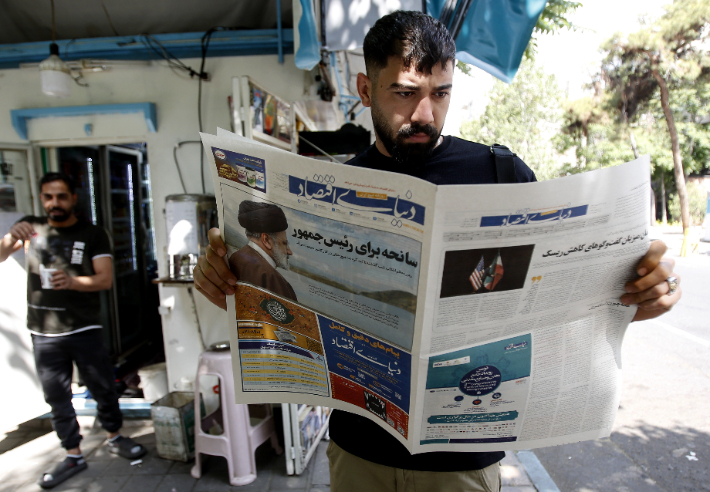 20일(현지시간) 이란 수도 테헤란에서 한 시민이 에브라힘 라이시 대통령 사망 소식이 담긴 신문을 읽으며 심각한 표정을 짓고 있다. 연합뉴스