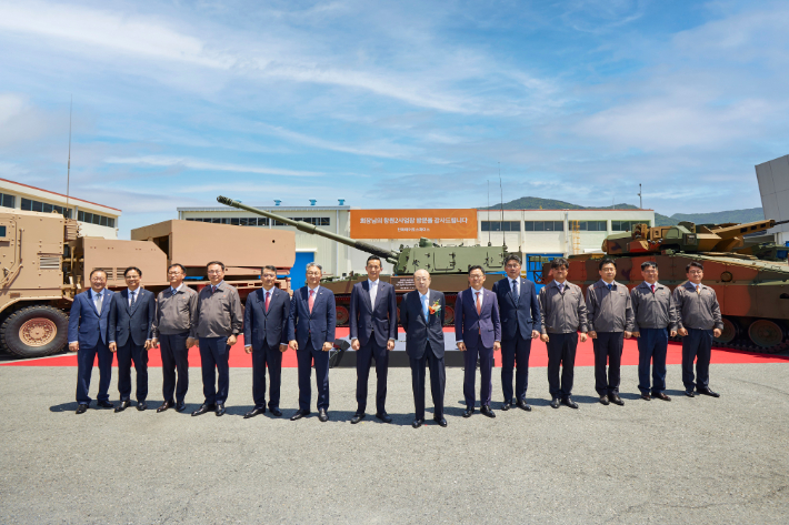 지난 20일 최근 통합 1년을 맞은 한화에어로스페이스 방산부문 창원사업장을 방문한 한화그룹 김승연 회장과 김동관 부회장 등 주요 경영진들이 주력 제품 앞에서 기념 촬영하고 있다. 한화 제공