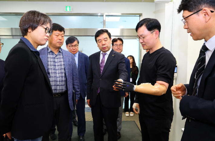 근로복지공단 박종길 이사장(가운데)과 이사들이 27일 재활공학연구소에서 이사회를 연 뒤 바이오닉 기술이 적용된 재활보조기구를 살펴보고 있다. 근로복지공단 제공