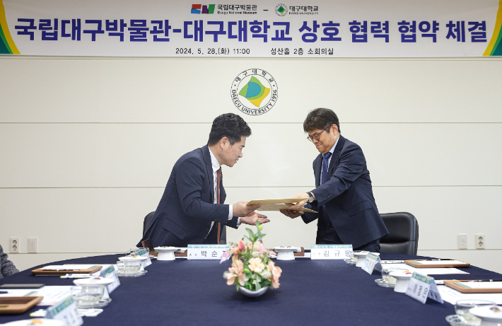 대구대 박순진 총장과 김규동 대구박물관장이 상호협력 협약을 체결한 뒤 협약서를 교환하고 있다. 대구대 제공 
