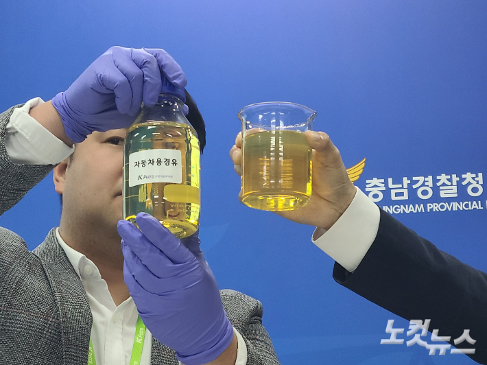 한국석유관리원 관계자들이 '가짜 경유(오른쪽)'와 정상 경유를 비교해 보이고 있다. 김정남 기자