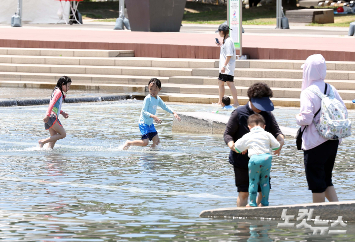 서울 낮 최고기온이 29도까지 오르며 초여름 날씨를 보인 4일 오후 서울 여의도 물빛광장을 찾은 시민들이 물놀이를 즐기고 있다. 황진환 기자