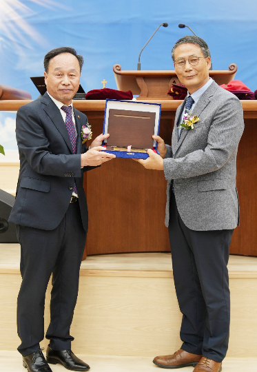 남선교회 45주년 기념사업 추진위원장 임화발 장로가 선교대회에서 말씀을 전한 이염광 선교사에게 교회건축 헌당기념패를 전달하고 있다. 남선교회 제공