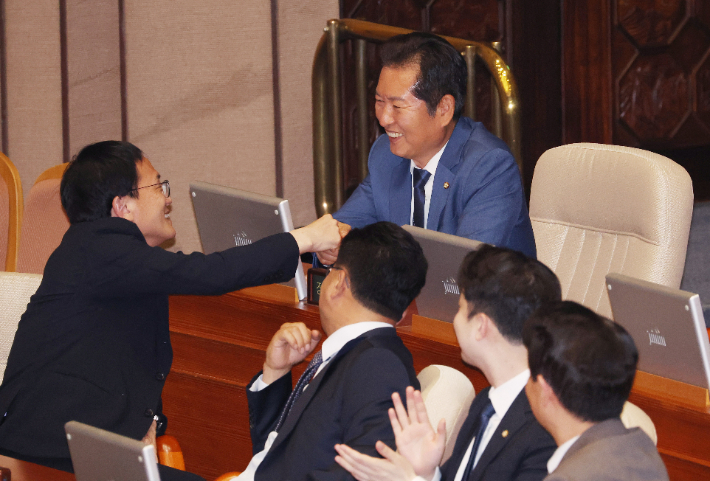 더불어민주당 정청래, 박주민 의원이 10일 국회에서 열린 본회의에서 상임위원장으로 선출되자 서로 축하하고 있다. 연합뉴스