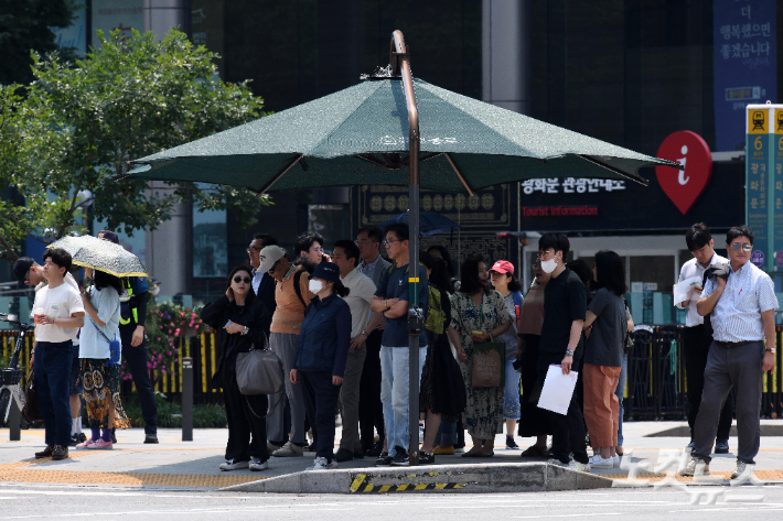 시민들이 횡단보도 그늘막에서 신호를 기다리고 있다. 박종민 기자
