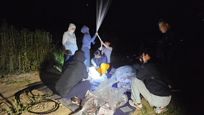 탈북민 단체 겨레얼통일연대 회원들이 지난 7일 밤 강화도에서 대북 전단을 살포하는 모습. 겨레얼통일연대 측 제공