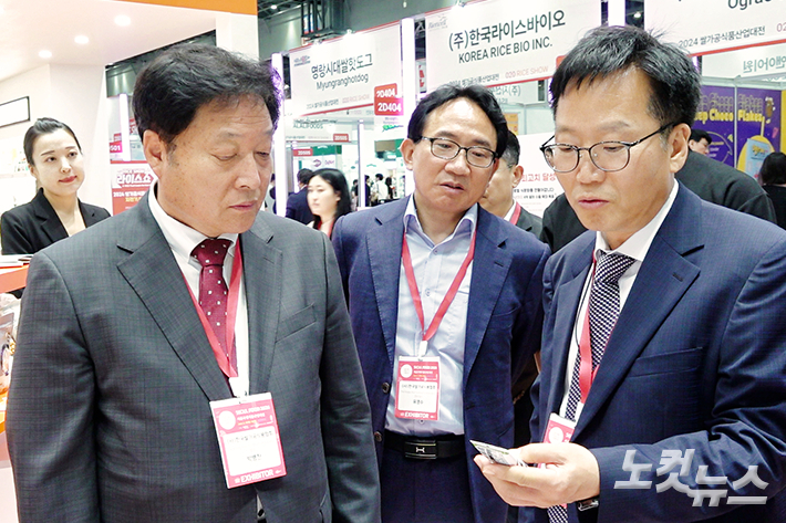 라이스쇼에서 쌀가공 식품을 보고 있는 최명철 농림축산식품부 최명철 식량정책관(왼쪽)과 한국쌀가공식품협회 박병찬 회장(왼쪽). 노컷TV 영상 캡처
