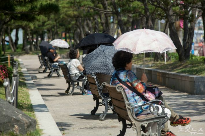 무더위에 양산을 쓰고 휴식하는 시민들. 송호재 기자