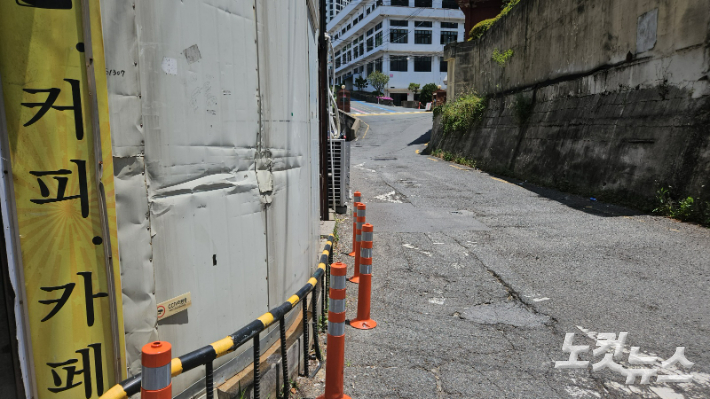 부산 해운대구 반여동 쿠팡물류센터 앞 건물 벽이 파손된 모습. 경찰은 지난달 교통 사망사고 이후 시선유도봉을 설치했다. 김혜민 기자 