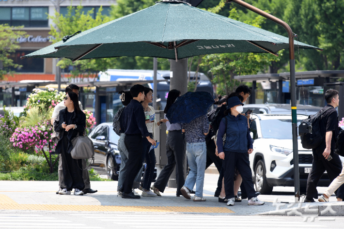 횡단보도 그늘막에서 신호를 기다리는 시민들. 박종민 기자