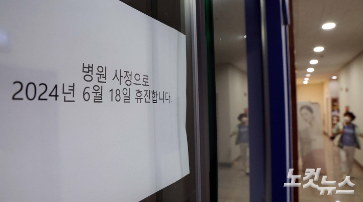 개원의들이 소속된 대한의사협회(의협)가 하루 총파업 휴진에 돌입한 18일 오전 서울시내 한 의원을 찾은 환자가 '휴진' 안내문을 보고 발길을 돌리고 있다. 황진환 기자
