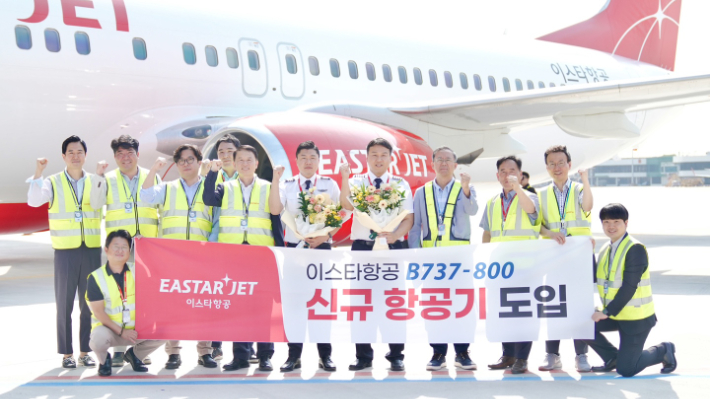 지난 21일 김포국제공항에 도착한 이스타항공 11호기 앞에서 조중석 대표이사(오른쪽 4번째) 등 이스타항공 임직원들이 기념 촬영을 하고 있다. 이스타항공 제공