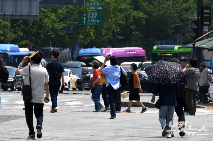 시민들이 부채와 양산으로 햇볕을 가리며 발걸음을 옮기고 있다. 박종민 기자