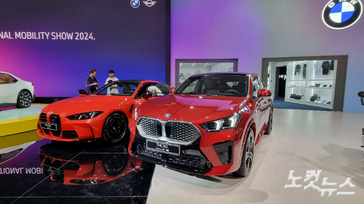 BMW가 부산모빌리티쇼에서 선보인 전기 SAC iX2(오른쪽)과 고성능 쿠페 M4. 윤준호 기자